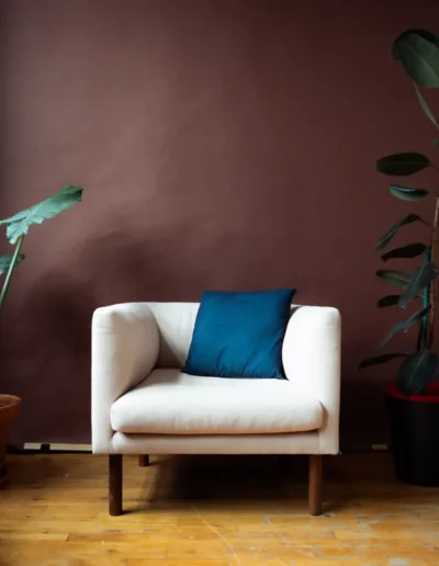 Décor mur bordeaux avec fauteuil blanc au Studio Popcorn