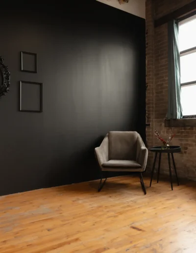 Décor mur noir avec fauteuil au studio photo à Montréal